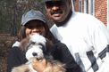 Couple holding tan-and-white Tibetan Terrier